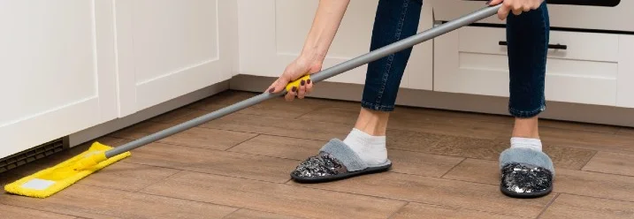 Person wischt mit Wischmopp Boden